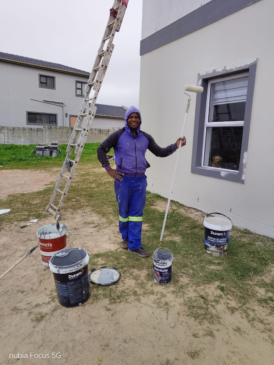 Team member with roller and quality Duram paints on site
